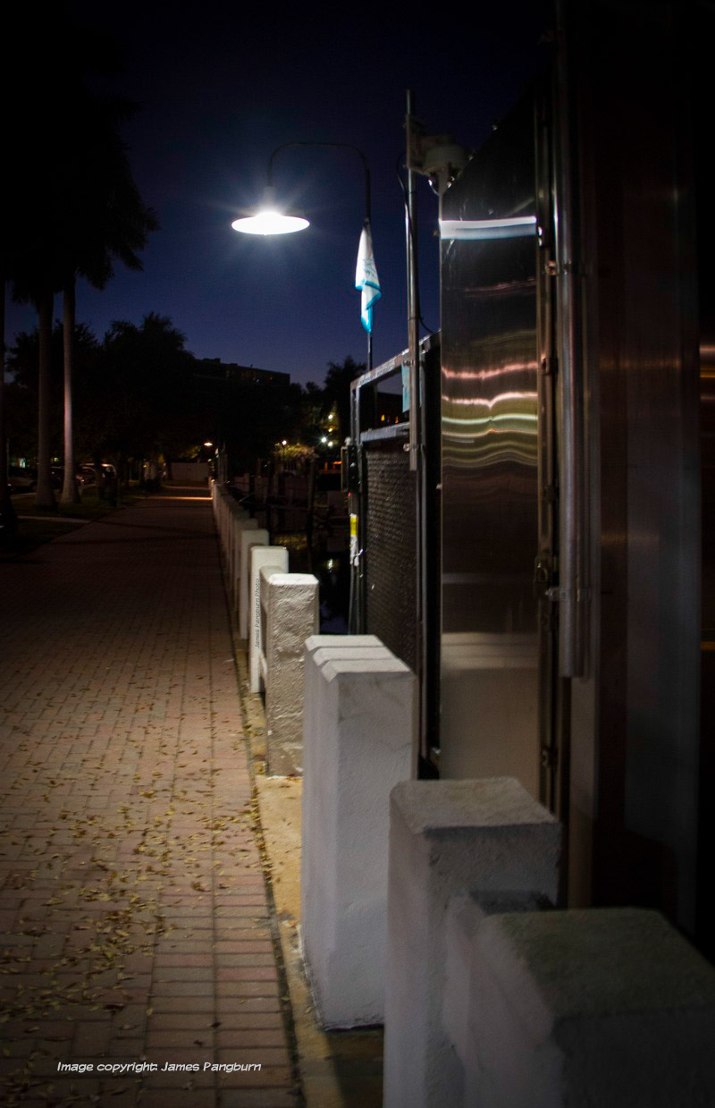 Brick walkway at night with an overhead lamp illuminating a portion of it demonstrating how you should let your light shine in the darkness