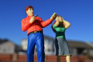male figurine with gun and female figurine in fear