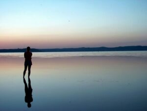 woman standing water at sunset