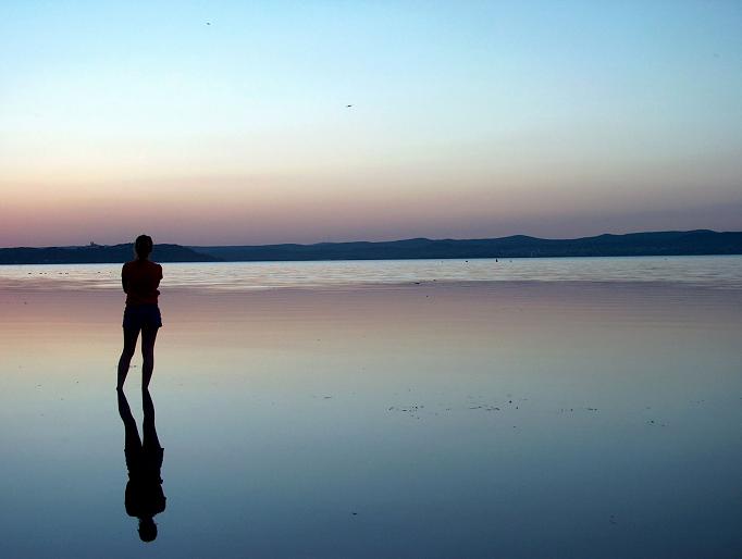 woman standing water at sunset