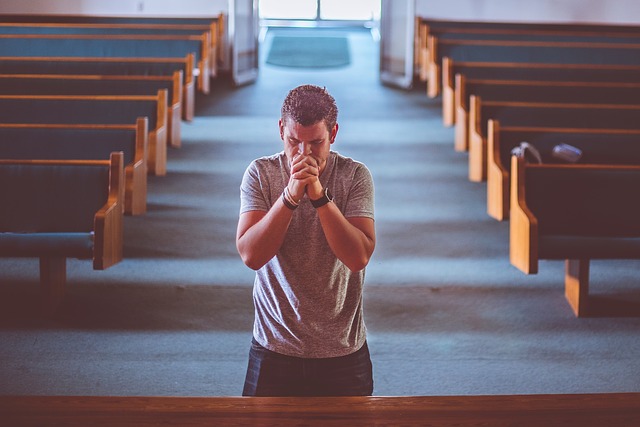 man standing with arms folded in prayer