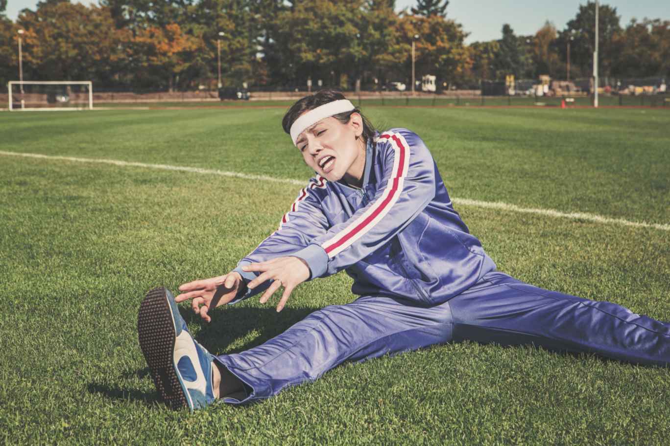 woman exercising in athletic field making a lot of efforts to get fit