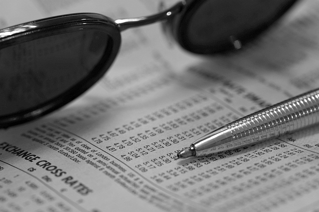 glasses and pen on sheet of financial rates