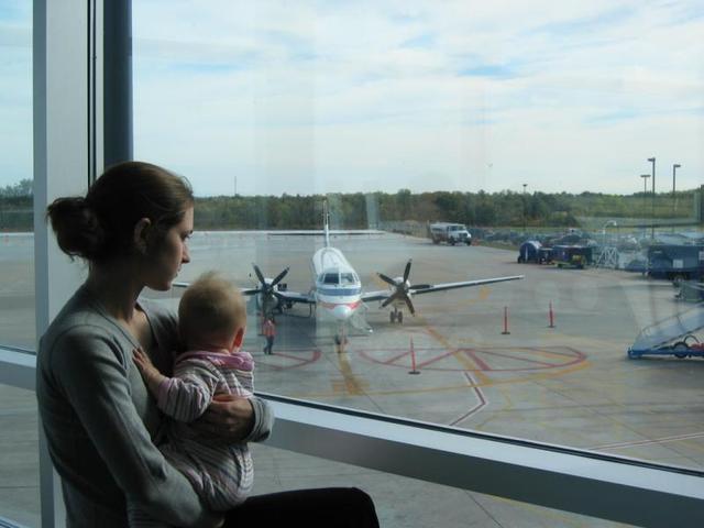 mother baby looking at plane