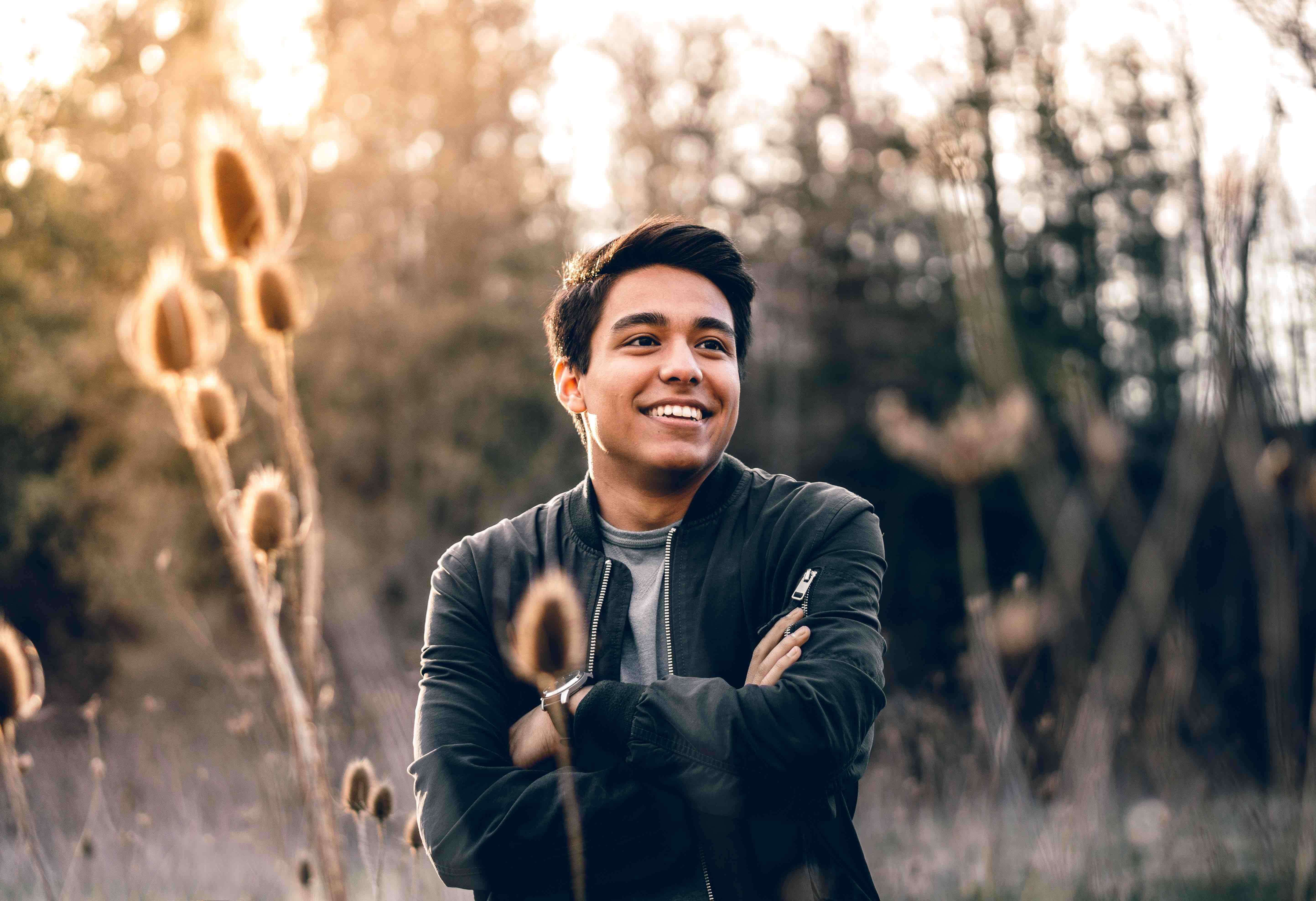 man smiling with folded arms symbolic of one who shows the deliverance from captivity of sin with regular outward happiness