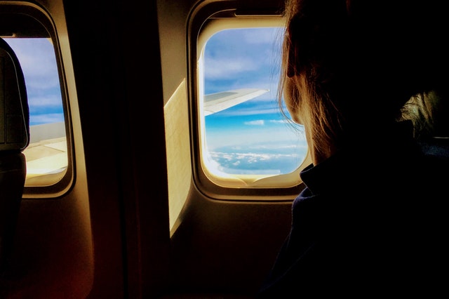 woman looking out airplane window