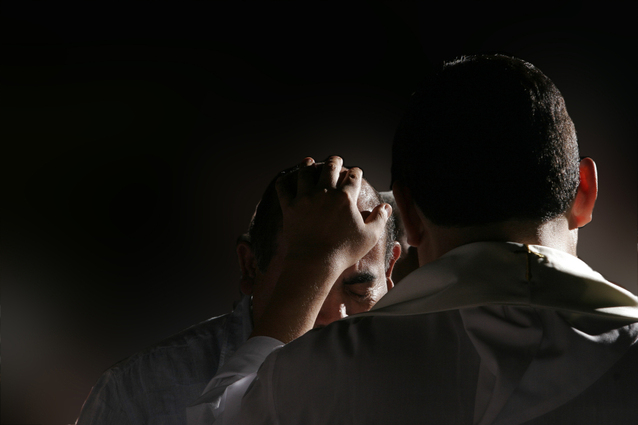 man praying for another man