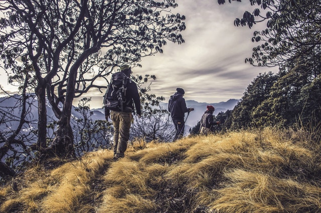 hikers on small clearing of hill who have chosen to travel on and not give up