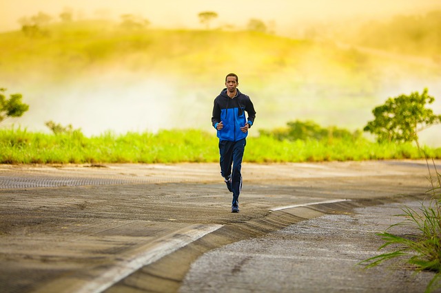 a man jogging on a curved section of road with a yellow foggy background