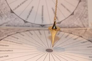 A photo of a gold pendulum swinging on a printed diagram