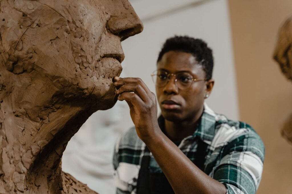 A man forming a sculpture while picturing the final result symbolically of how God delights in us because He is looking at the end and not the process