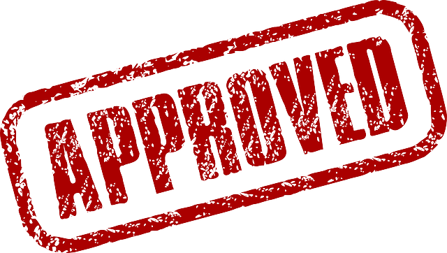 Red approved stamped on white surface