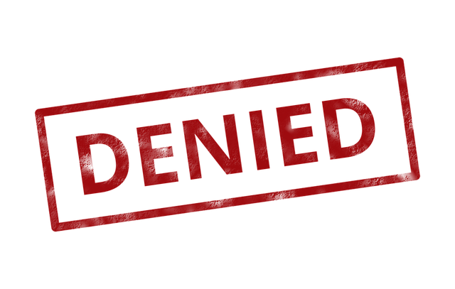 Red 'denied' inside of retangular box stamped on white surface