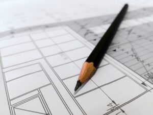 A photo of a pencil laying on an architectural drawing that is fading as a blur into the background