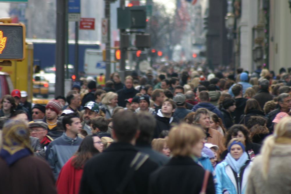 A crowd of people walking on a street in New York City symbolizing the choice of loving this present world