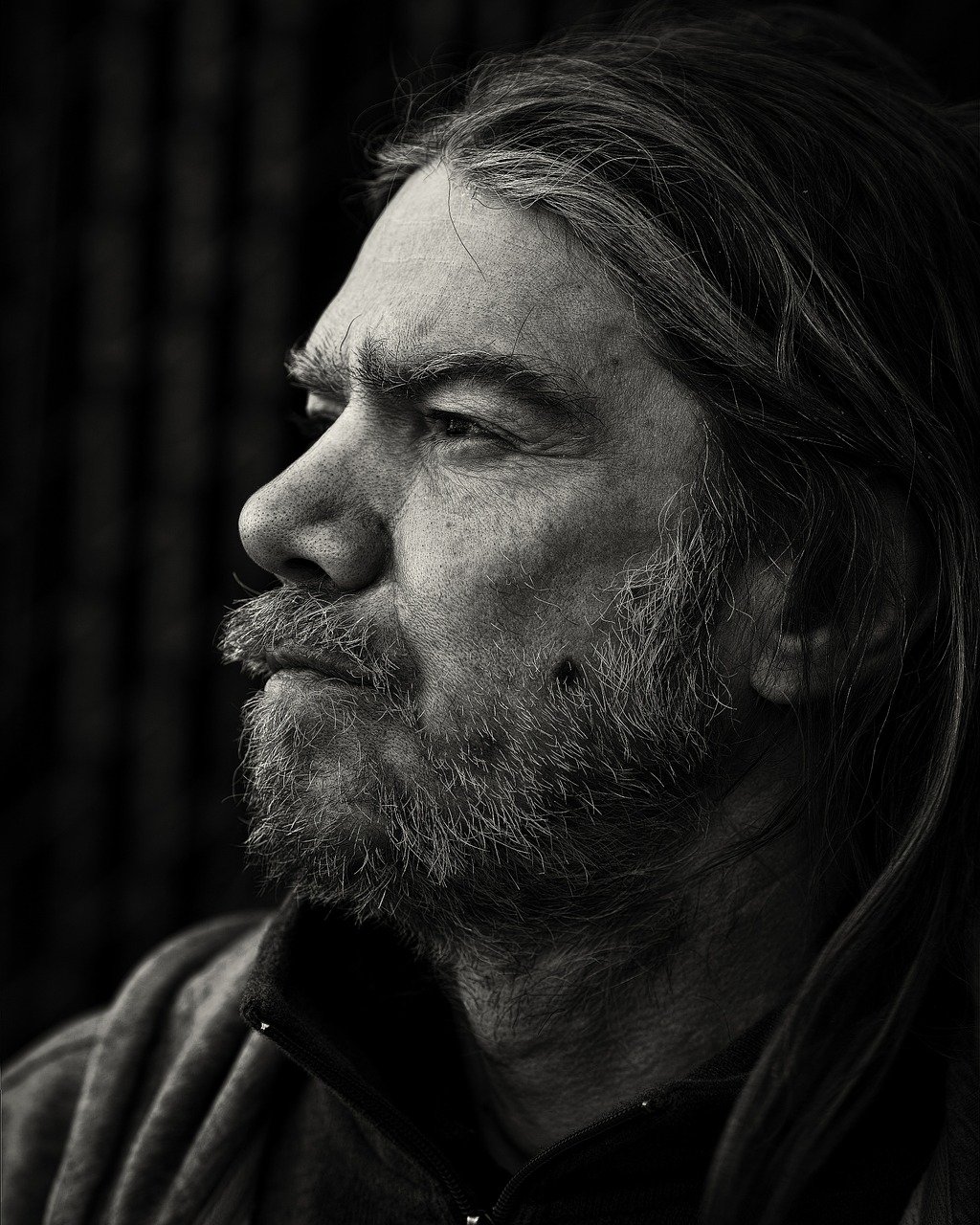 A black and white head shot of a man with a beard and mustache