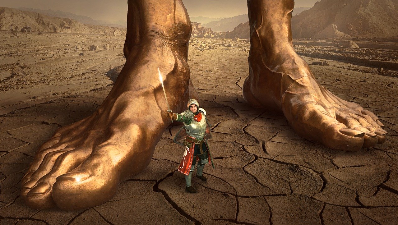 Fantasy illustration of a small warrior standing between two giant feet in a desert wilderness