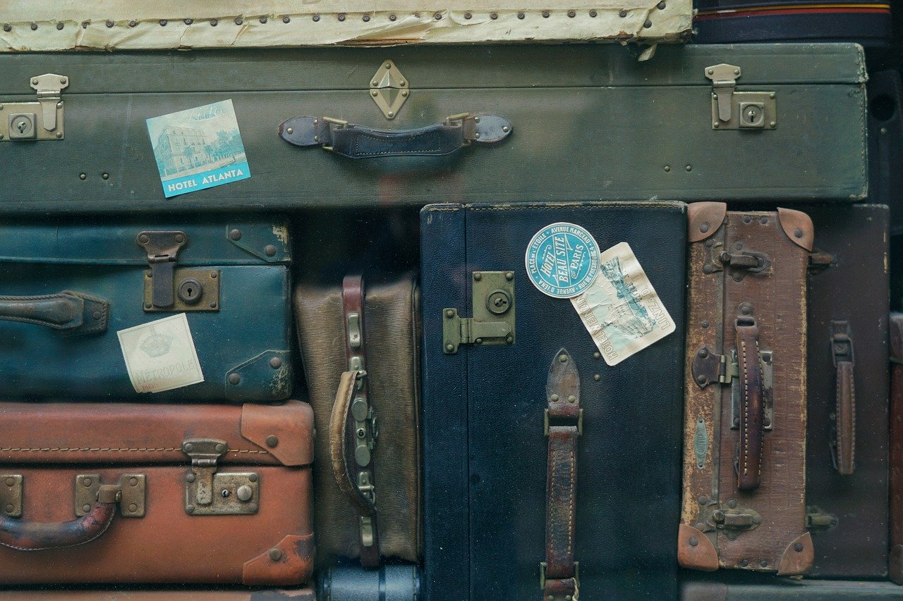 A collection of assorted old baggage displayed with handles outward