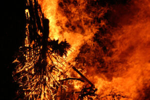 A large brush fire with billowing flames in the night sky