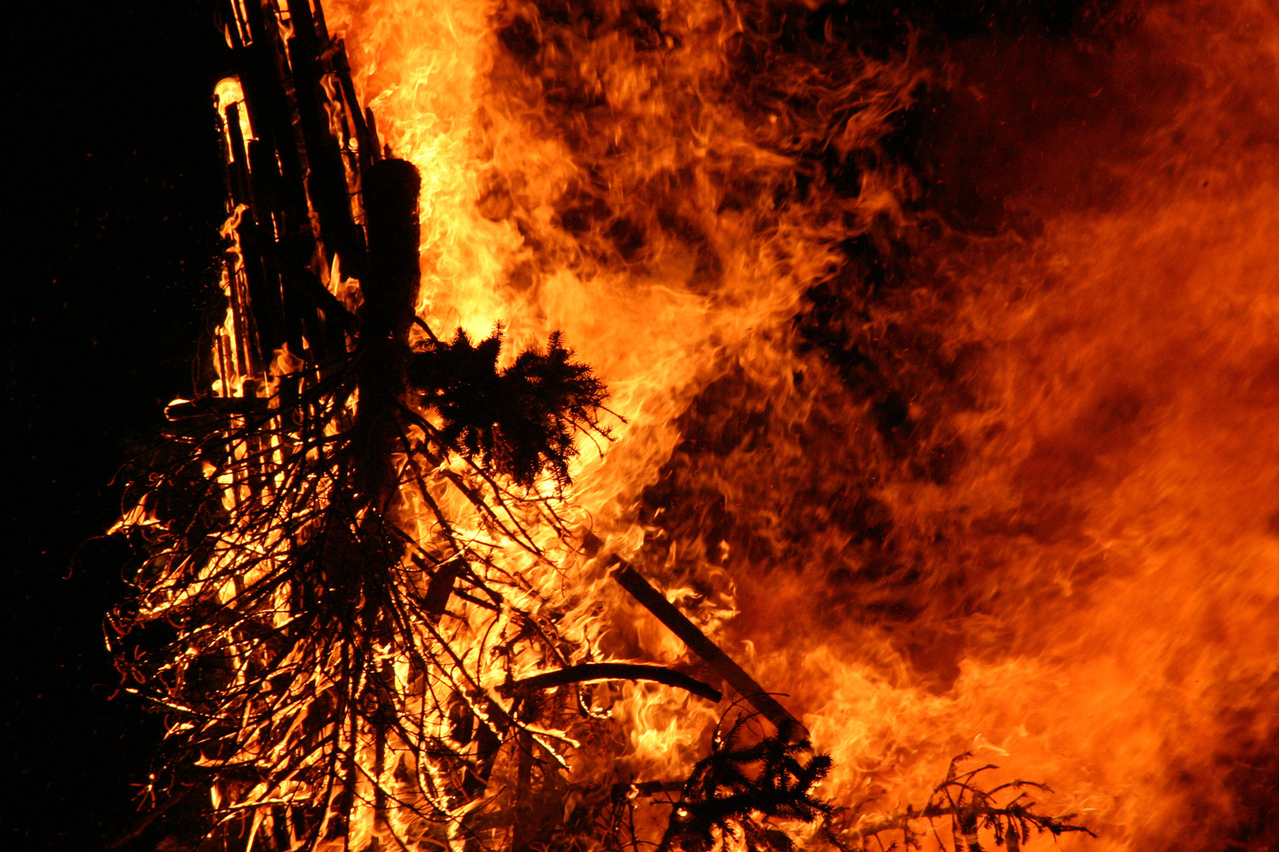 A large brush fire with billowing flames in the night sky
