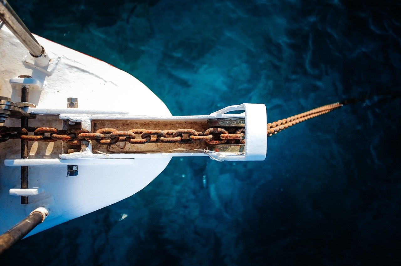 Overhead view of an anchor chain coming out from a ship and into the water