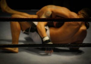 Two men wrestling in a lighted wrestling ring