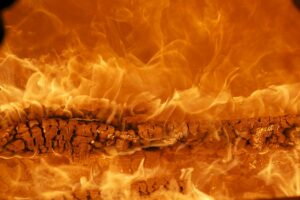 A photo full of intense flames emanating from a burning log in the center of the picture