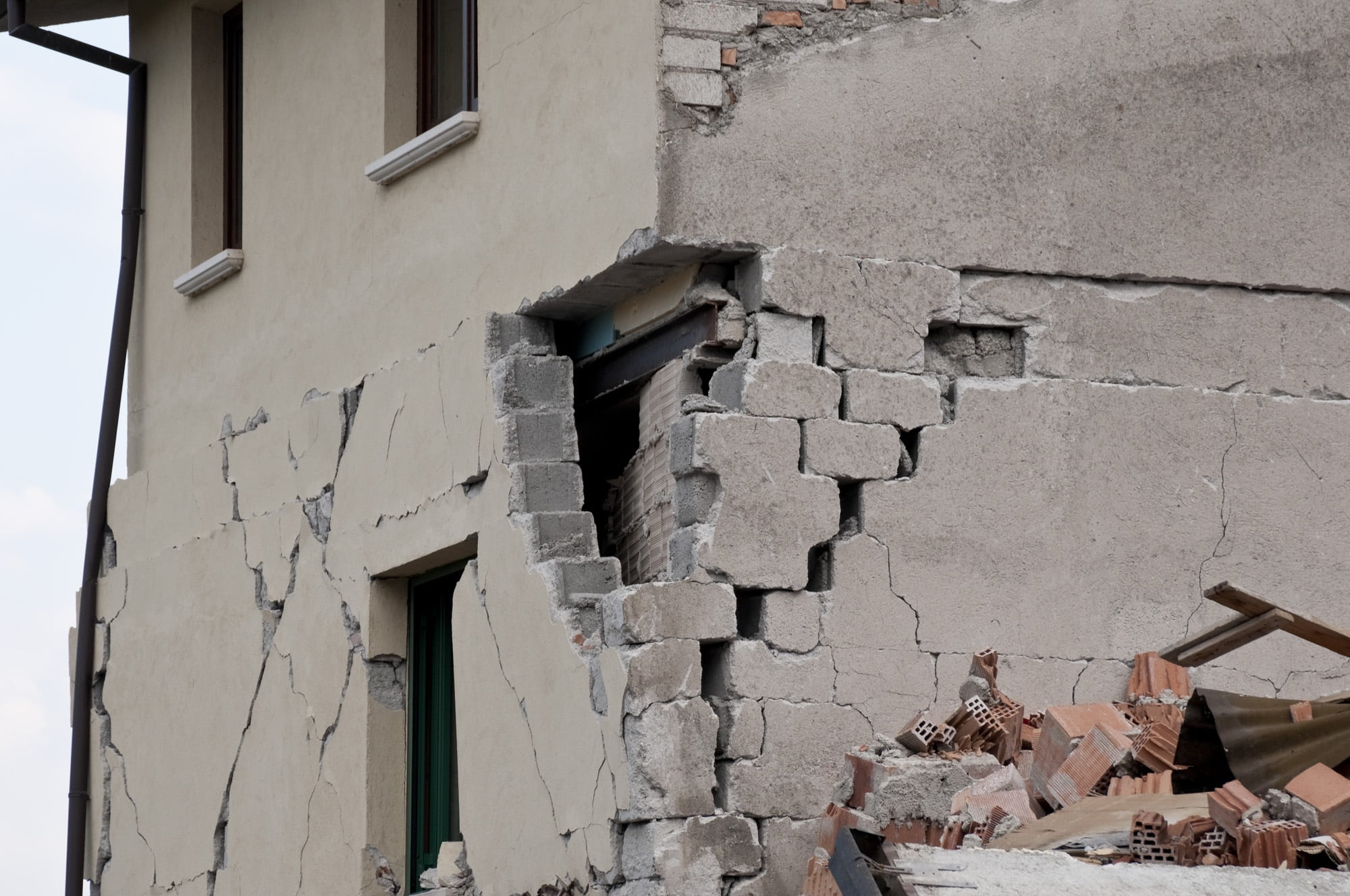 A photo of a close-up of a concrete block building with significant damage a corner of it and how this resembles sin in one's heart