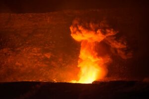 Volcano eruption in Hawaii with very large orange plume in distance