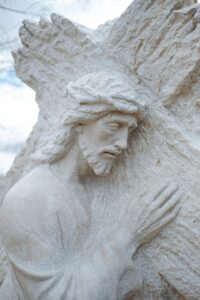 White stone sculpture of Jesus Christ holding cross