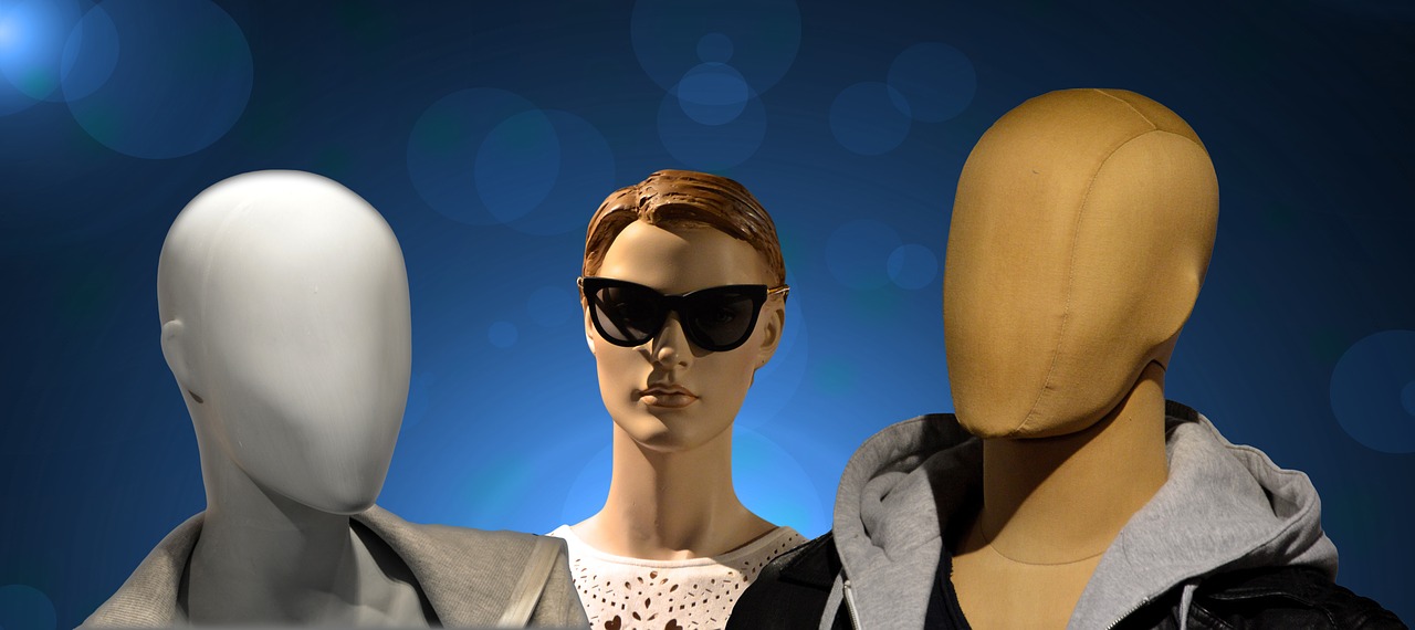A graphical image of three mannequin headshots, symbolic of deception, with one on the left having a blank grey face, the one in the center with parted brown hair and and facial features while wearing sunglasses, and the one on the right having a featureless tan face while wearing a hooded sweat jacket