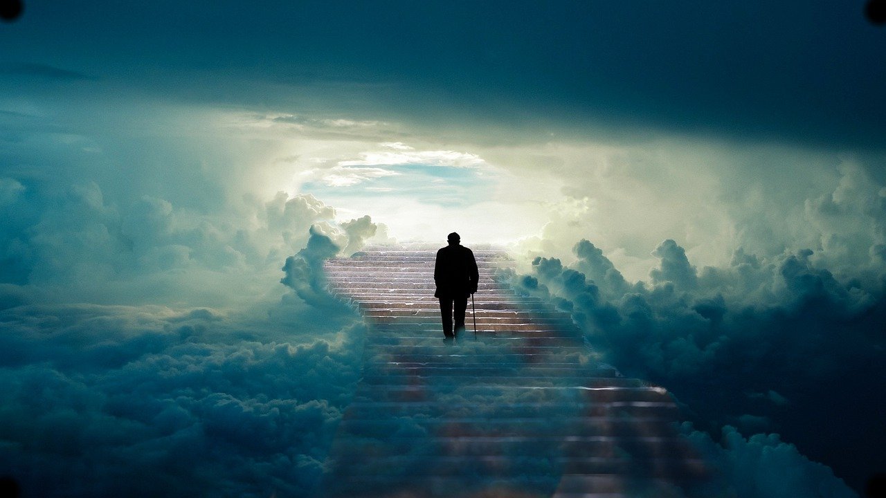 The backside of a older man walking with a cane up a long set of steps with and abundance of clouds surrounding on both sides