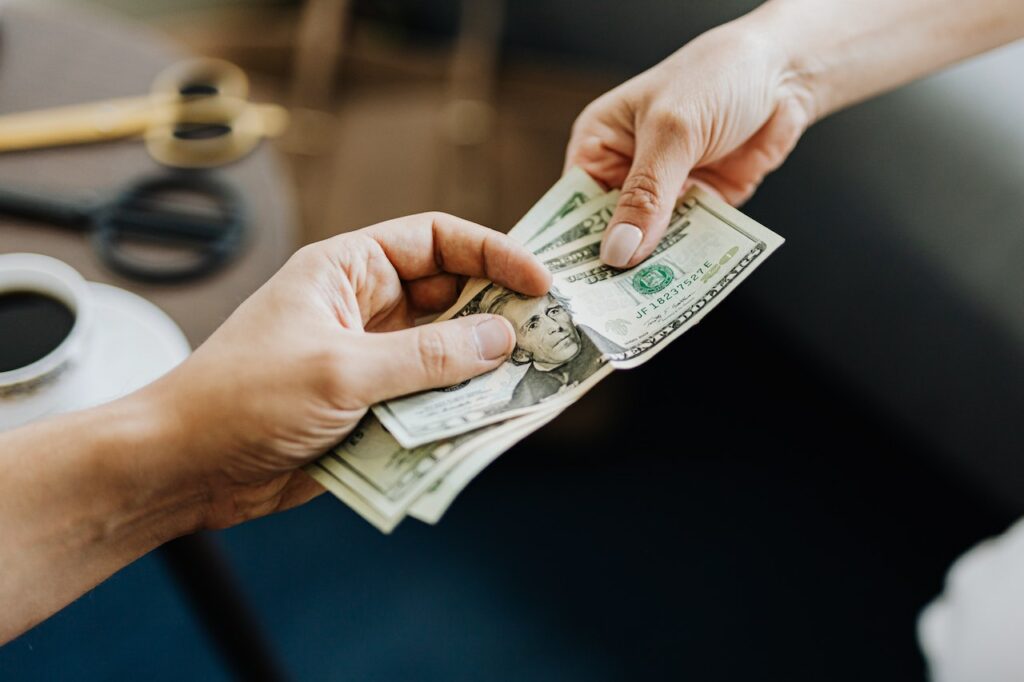 Money being exchanged between two hands possibly a bribe
