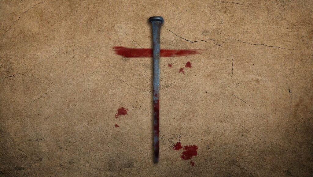 A photo of a spike against concrete lying over a streak of blood implying the blood of Christ.