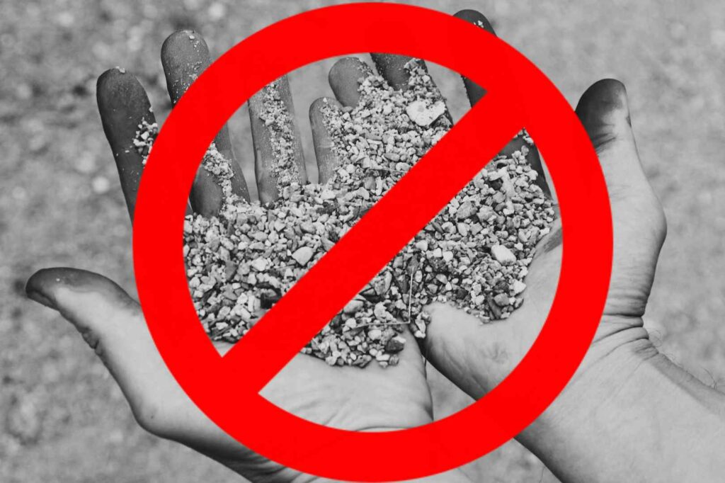 A black and white photo of a pair of blackened hands covered with gravel and dirt representing sin with a red circle and slash through it overlaid on top.