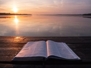 morning-bible-dock-water-aaron-burden-535Npq1wFG8-unsplash(https-::unsplash.com:photos:book-on-top-of-table-and-body-of-water-535Npq1wFG8)