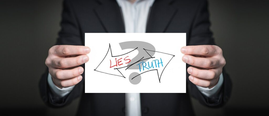 A sign held up with hands show a question mark between two opposing arrows showing the text of lies and truth demonstrating the results of a promise made.