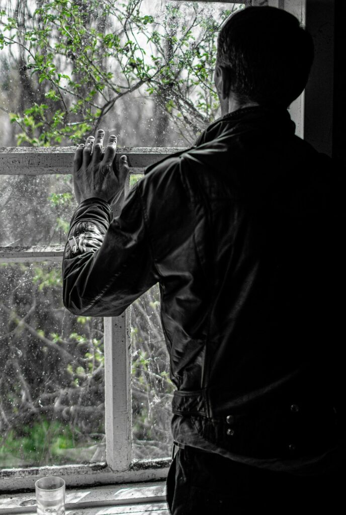 A photo of a man looking though a window symbolizing when you put focus on your past