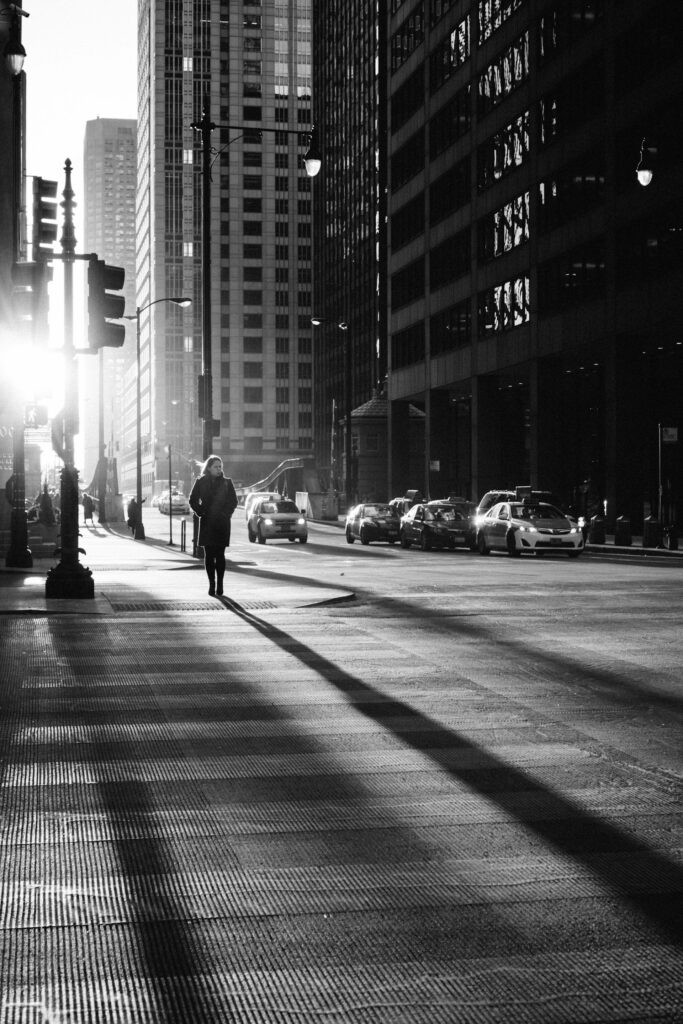A black and white photo of a woman walking down a city street symbolizing how one should be known in their walk with God
