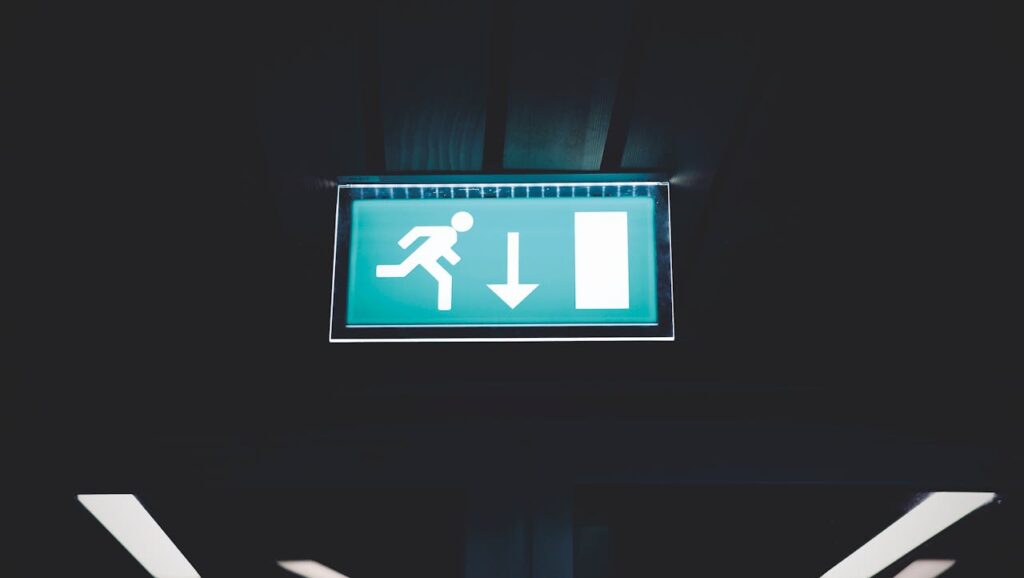 A lighted overhead sign showing a way to escape