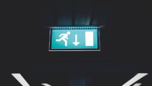 A lighted overhead sign showing a way to escape
