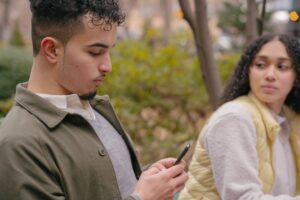 jealousy-pexels-budgeron-bach-6532613(https-::www.pexels.com:photo:hispanic-lady-looking-jealously-at-boyfriend-while-texting-on-cellphone-6532613:)