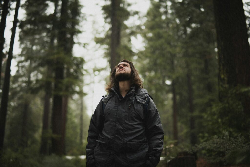 man-in-forest-looking-up-corey-agopian-eovZHPLjsb0-unsplash(https-::unsplash.com:photos:man-wearing-black-jacket-looking-up-surrounded-with-tall-trees-eovZHPLjsb0)