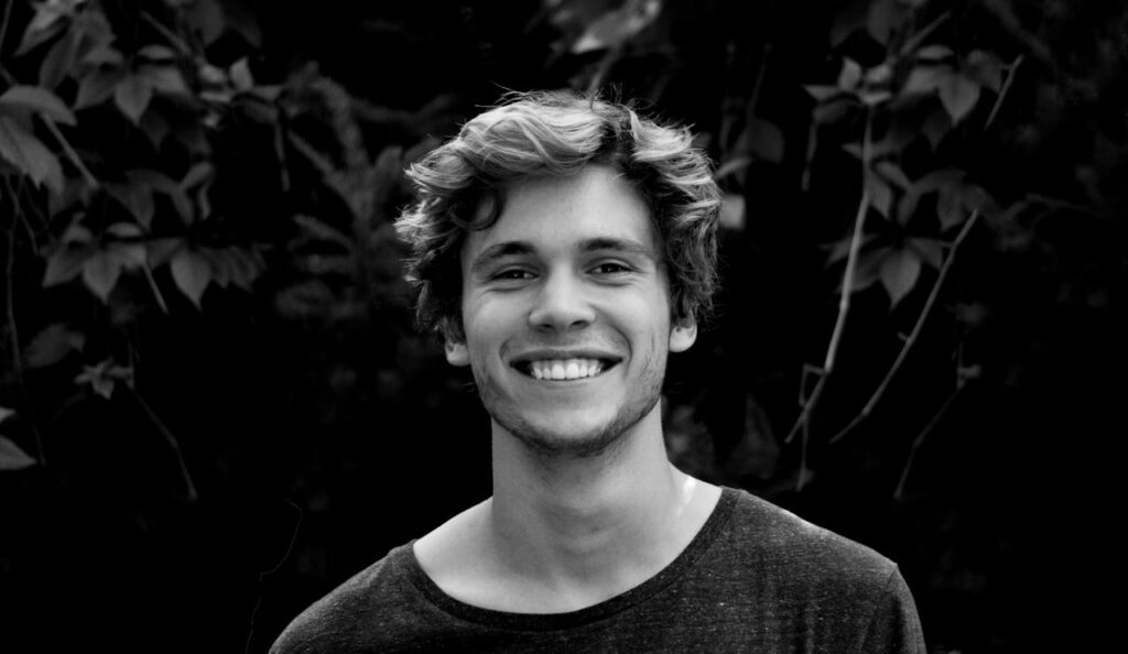 black and white photo of the headshot of a smiling young man